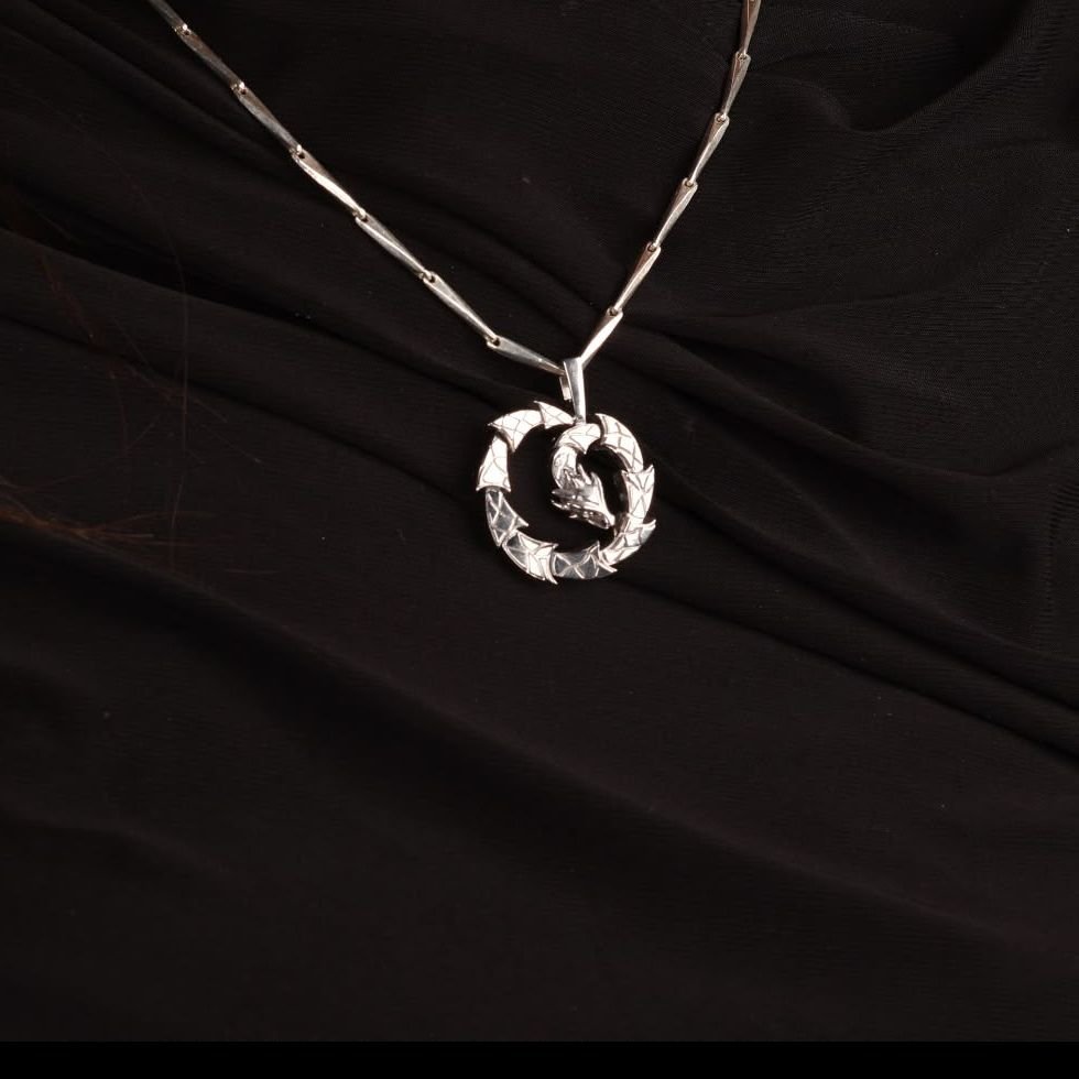 Circular dragon pendant with a scale texture, coiling around itself